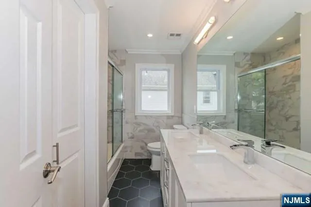 a spacious bathroom with a double vanity sink a mirror and a shower
