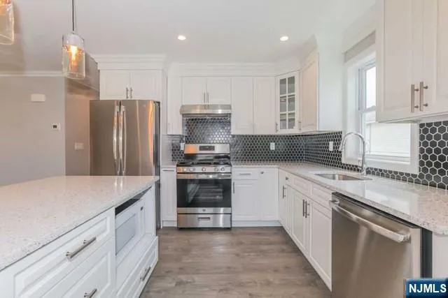a kitchen with stainless steel appliances a refrigerator sink and stove