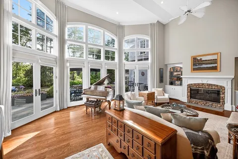 a living room with furniture a fireplace and a floor to ceiling window