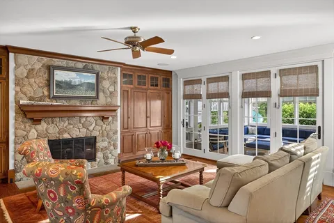 a living room with furniture a fireplace and a floor to ceiling window