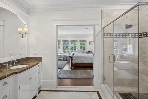 a en suite bathroom with a granite countertop sink and a mirror