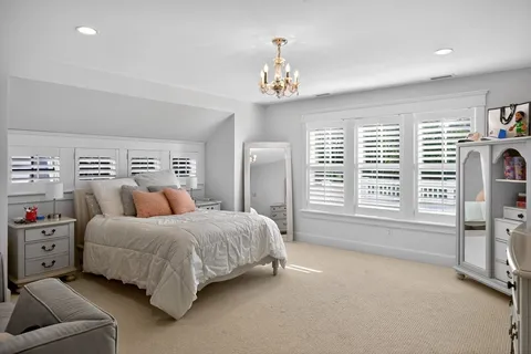 a spacious bedroom with a bed a couch and a large window