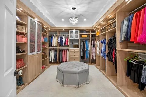 a view of walk in closet with clothes and shoes