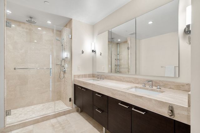a bathroom with a granite countertop sink mirror and shower