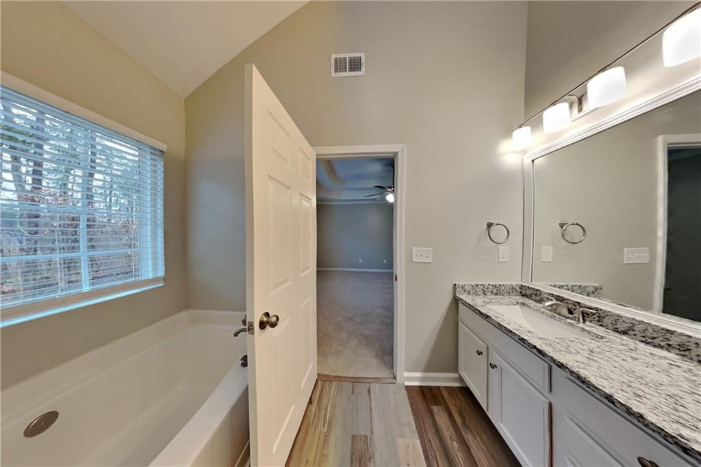 15 Jessica Lane Dallas, GA 30157 - Photo 9 of 23 a bathroom with a granite countertop tub sink a mirror and a shower