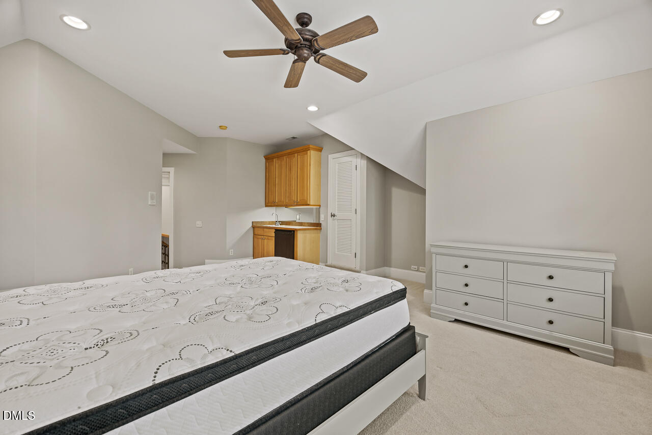 4004 Frontenac Court Apex, NC 27539 - Photo 39 of 61 a bedroom with a bed a chandelier and dresser