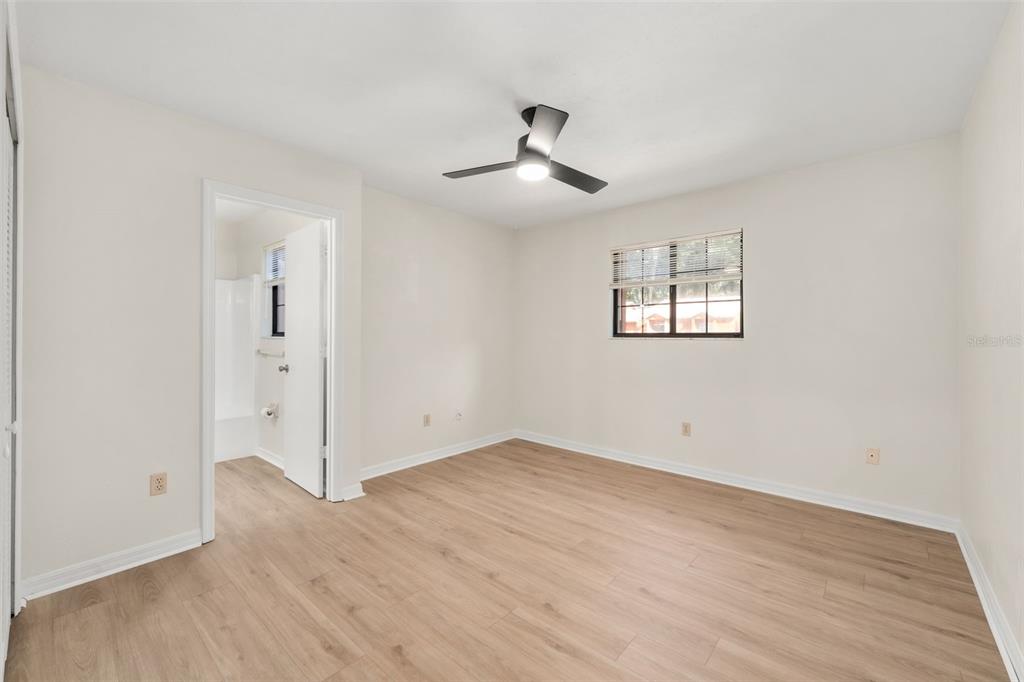 912 Southwest 57th Drive Gainesville, FL 32607 - Photo 18 of 34 an empty room with wooden floor ceiling fan and windows
