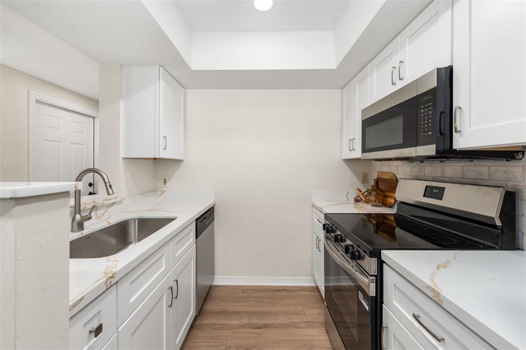 912 Southwest 57th Drive Gainesville, FL 32607 - Photo 2 of 34 a kitchen with a sink stove and microwave