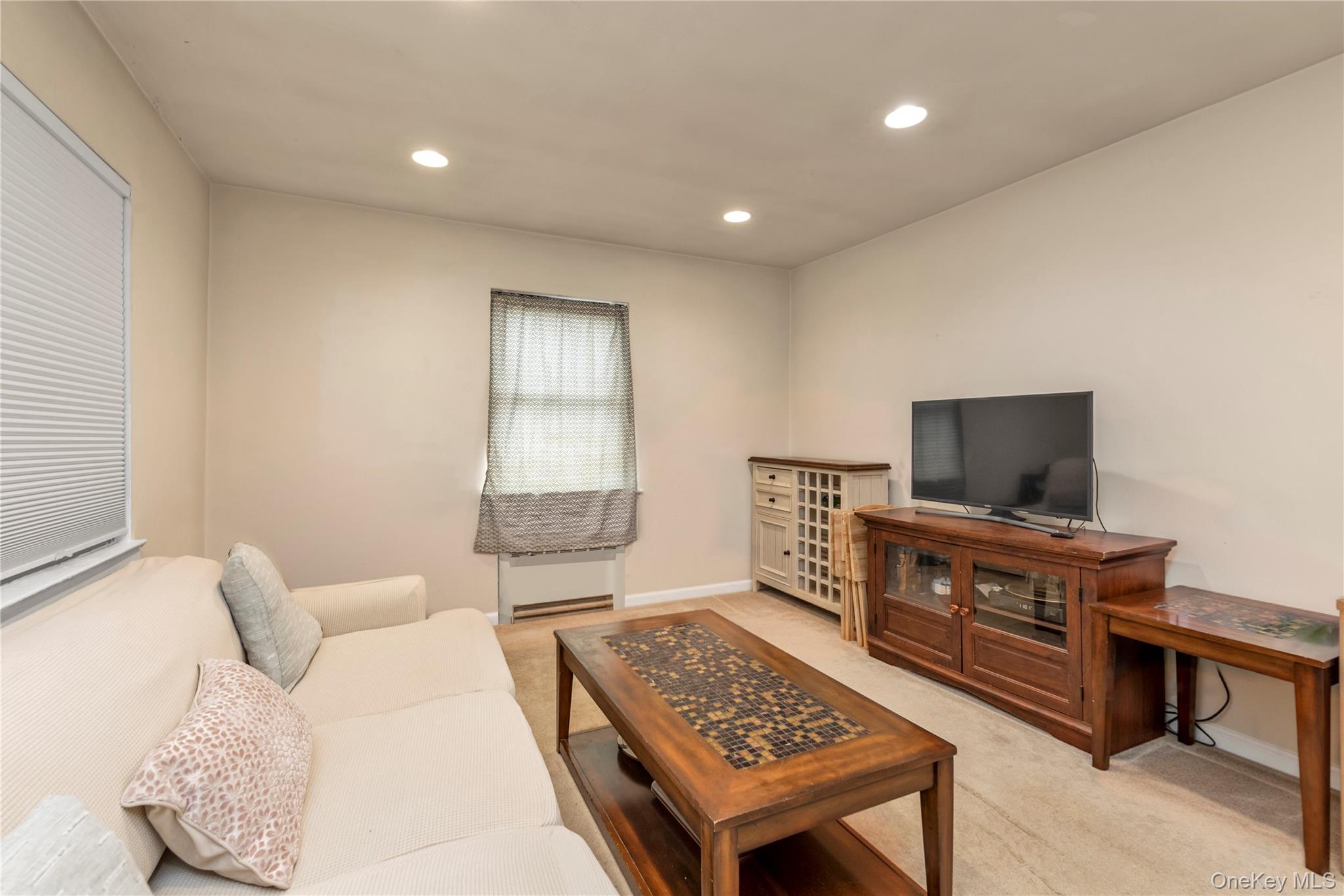 73-47 217th Street, Unit 364A2 Queens, NY 11364 - Photo 2 of 12 a living room with furniture and a flat screen tv