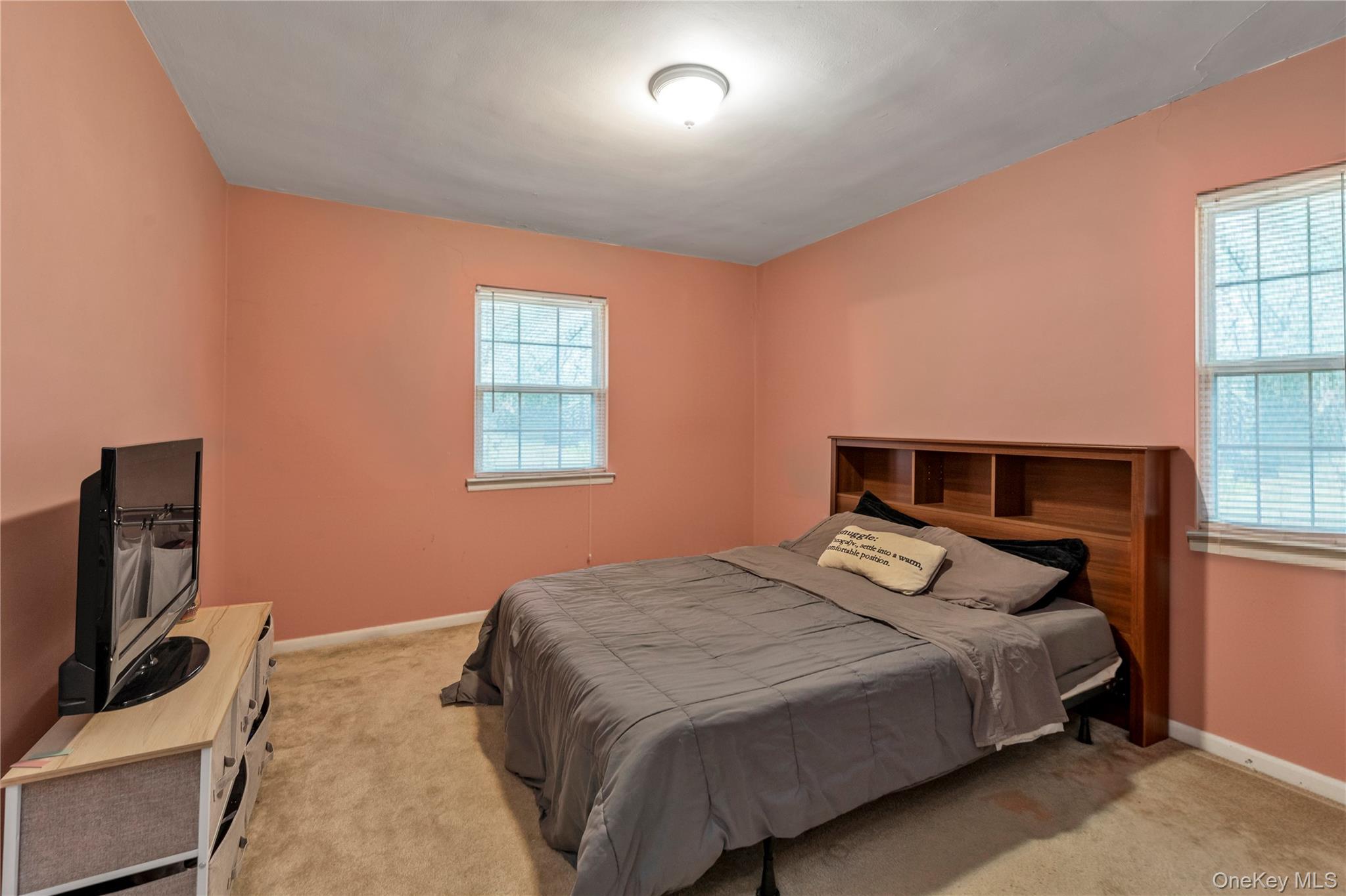 73-47 217th Street, Unit 364A2 Queens, NY 11364 - Photo 7 of 12 a bedroom with a bed and a flat screen tv