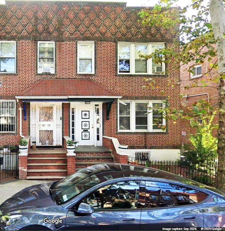 front view of a brick house with a yard