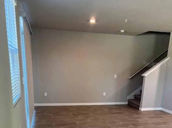 a view of a big room with wooden floor and windows