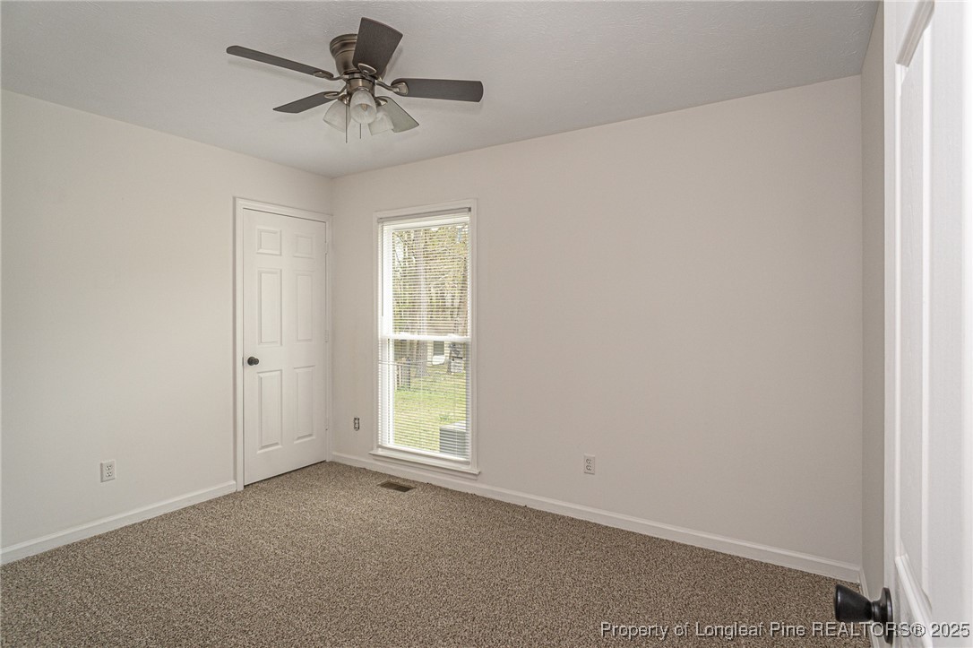 6576 Applewhite Road Fayetteville, NC 28304 - Photo 16 of 35 an empty room with a window and a ceiling fan