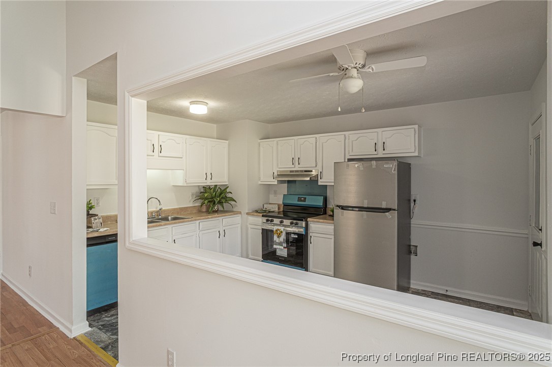 6576 Applewhite Road Fayetteville, NC 28304 - Photo 6 of 35 a kitchen with a refrigerator a stove top oven and cabinets