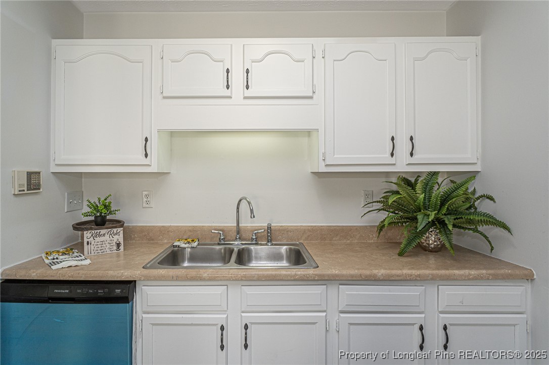 6576 Applewhite Road Fayetteville, NC 28304 - Photo 9 of 35 a kitchen with white cabinets a sink and dishwasher with white countertops