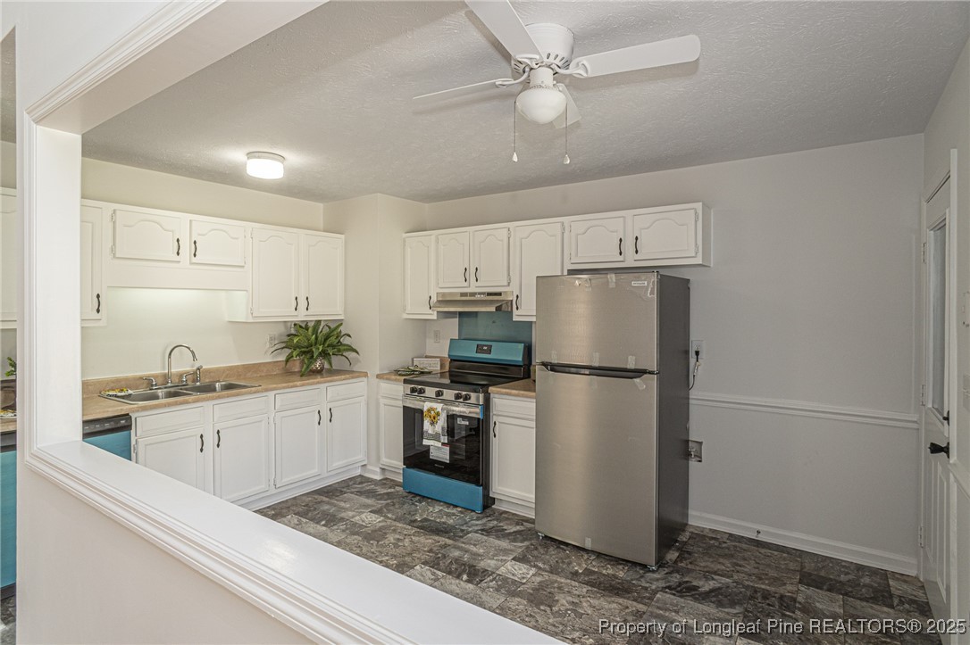 6576 Applewhite Road Fayetteville, NC 28304 - Photo 10 of 35 a kitchen with a refrigerator a sink and cabinets