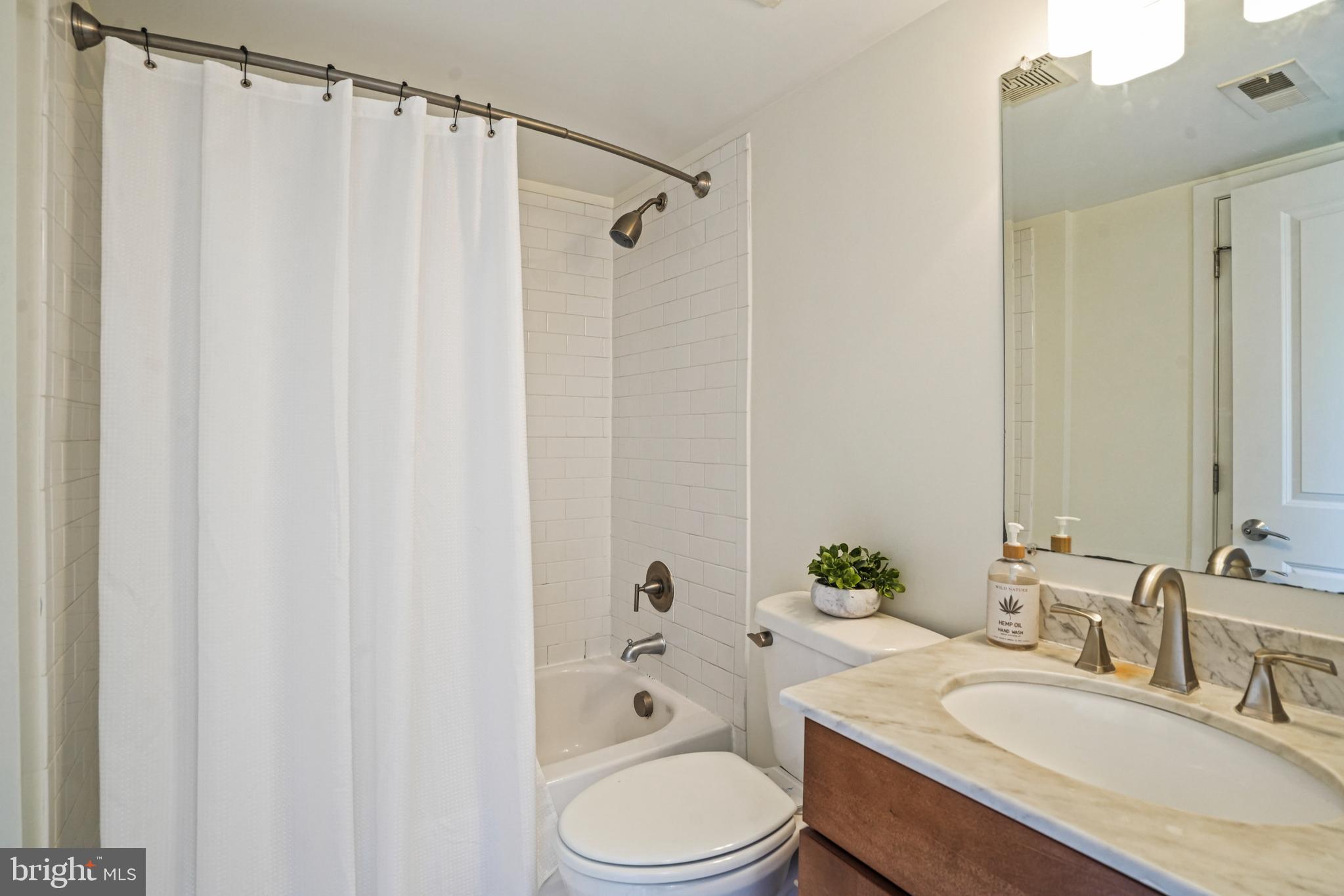 420 16th Street Southeast, Unit 103 Washington, DC 20003 - Photo 11 of 16 a bathroom with a granite countertop sink toilet and shower