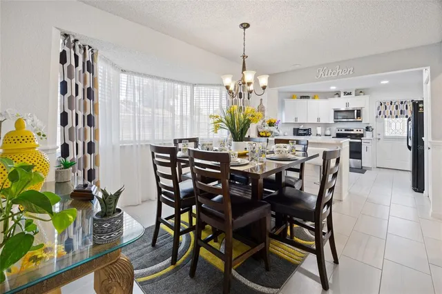 a view of a dining room with furniture a chandelier and wooden floor