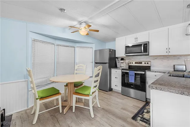 a view of kitchen with microwave stove top oven and cabinets