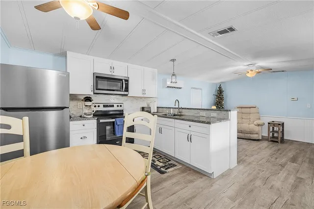 a kitchen with a refrigerator a stove top oven a sink dishwasher and a refrigerator with wooden floor