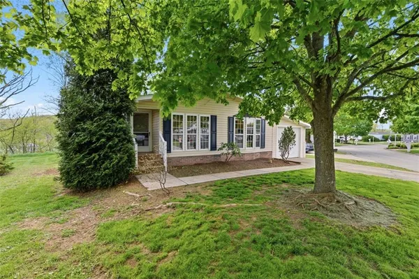 a view of a house with backyard and a tree