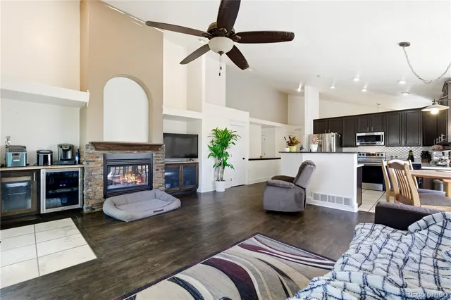 a living room with furniture fireplace and kitchen view