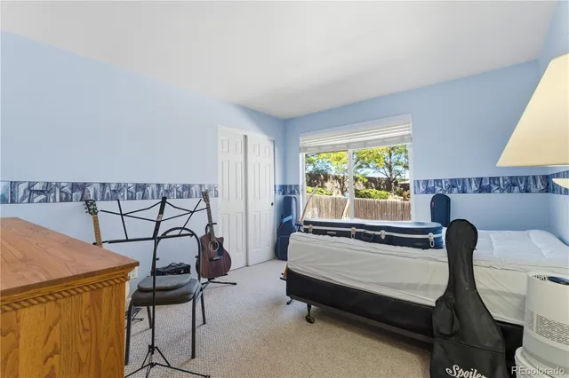 a bedroom with a bed a lamp and a large window