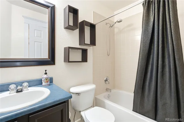 a bathroom with a granite countertop sink toilet and shower