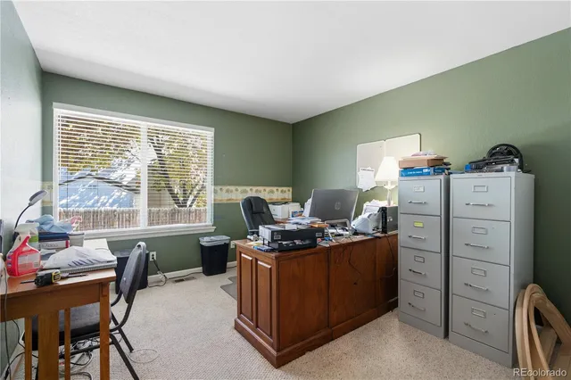 a view of a workspace with furniture and a window