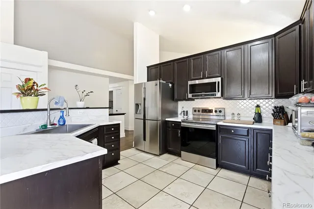 a kitchen with stainless steel appliances a stove refrigerator sink and microwave
