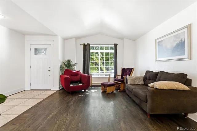 a living room with furniture stairs and a window