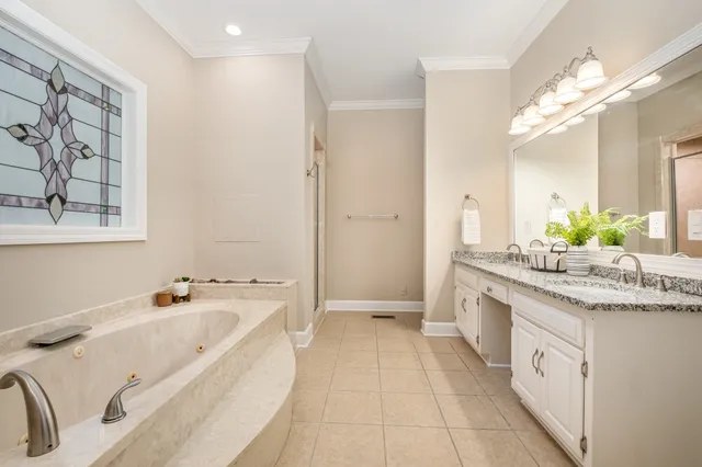a spacious bathroom with a granite countertop tub sink and mirror
