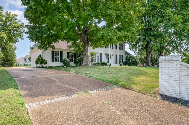 a front view of a house with yard and green space