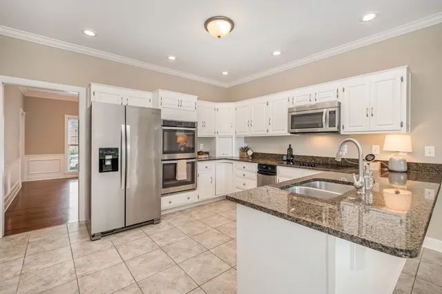 a kitchen with stainless steel appliances granite countertop a refrigerator and a sink