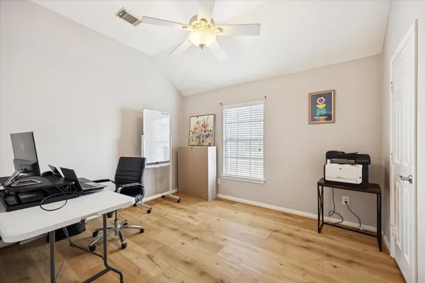 a view of a workspace with furniture and a window
