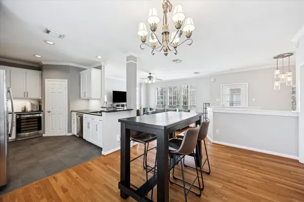 a view of a dining room with furniture a kitchen and chandelier