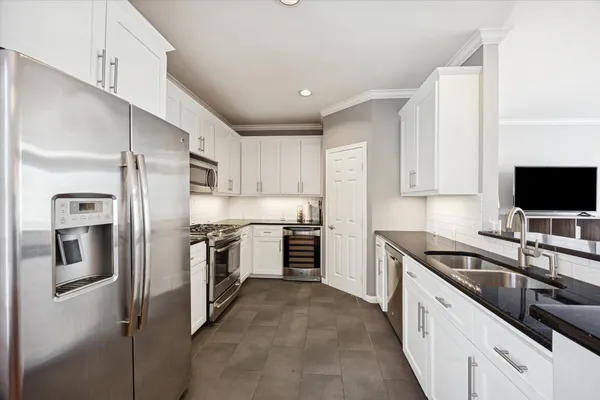 a kitchen with stainless steel appliances granite countertop a sink and refrigerator