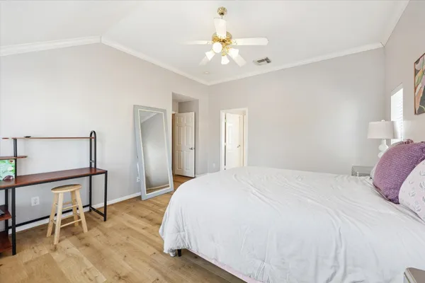 a spacious bedroom with a bed and a chandelier