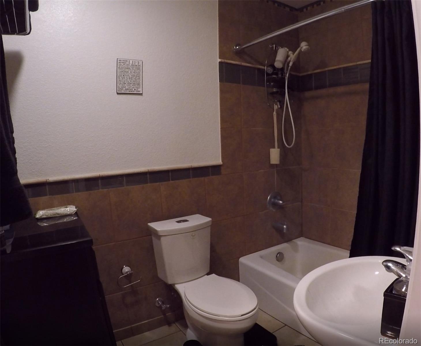 8148 Sweet Water Road Lone Tree, CO 80124 - Photo 11 of 13 a white toilet sitting next to a bathroom sink