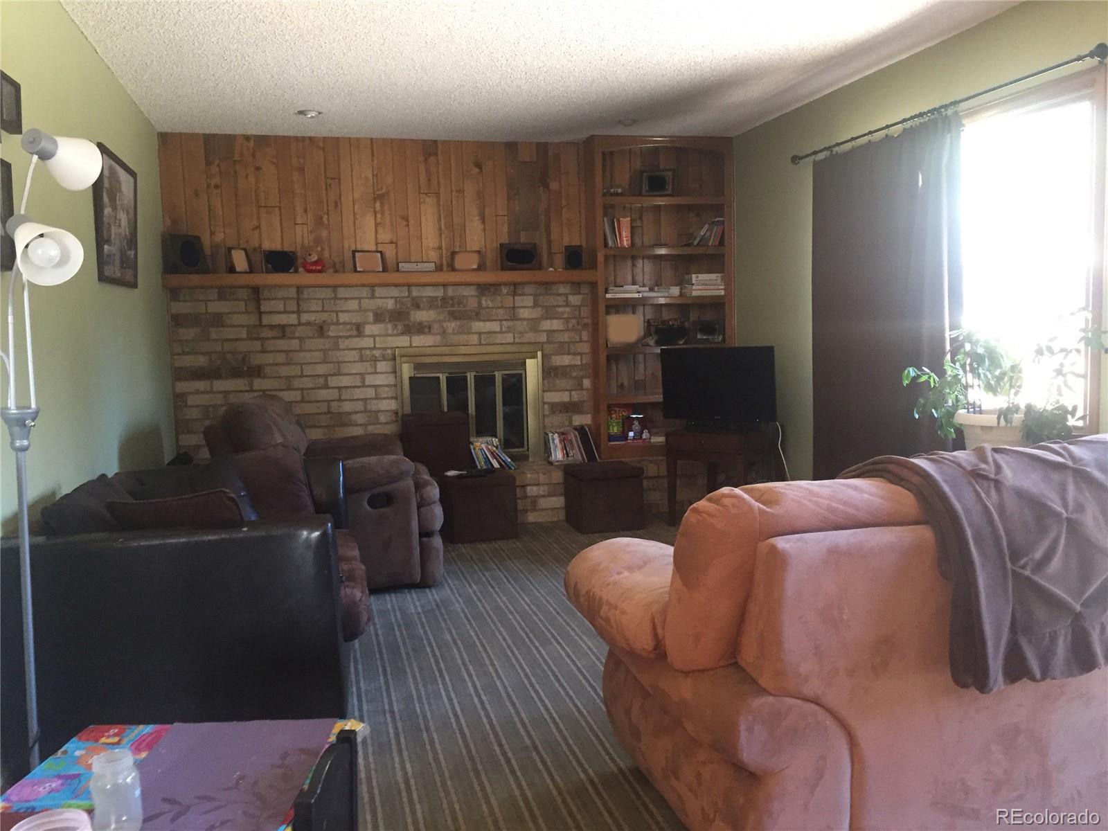 8148 Sweet Water Road Lone Tree, CO 80124 - Photo 3 of 13 a bedroom with furniture and a fireplace