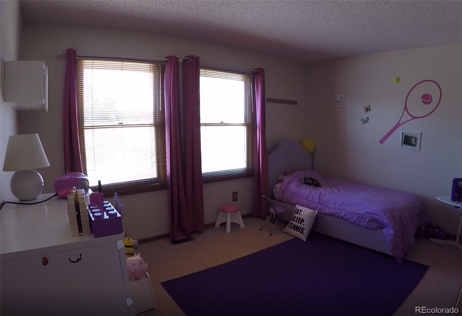8148 Sweet Water Road Lone Tree, CO 80124 - Photo 7 of 13 a bedroom with a bed and windows