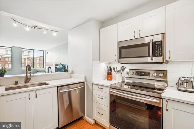 a kitchen with stainless steel appliances a refrigerator sink and cabinets