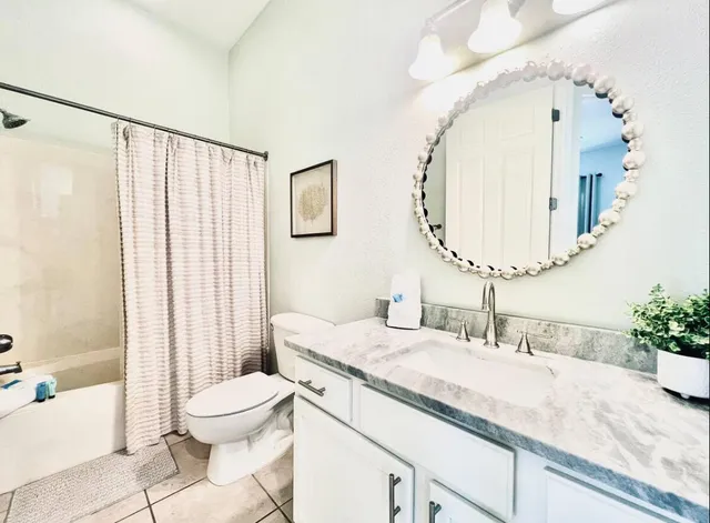a bathroom with a granite countertop sink mirror vanity and toilet