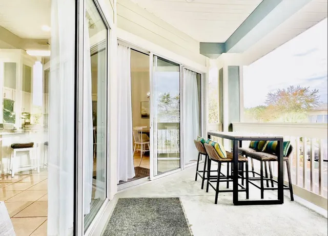 a view of a dining room with furniture and a floor to ceiling window