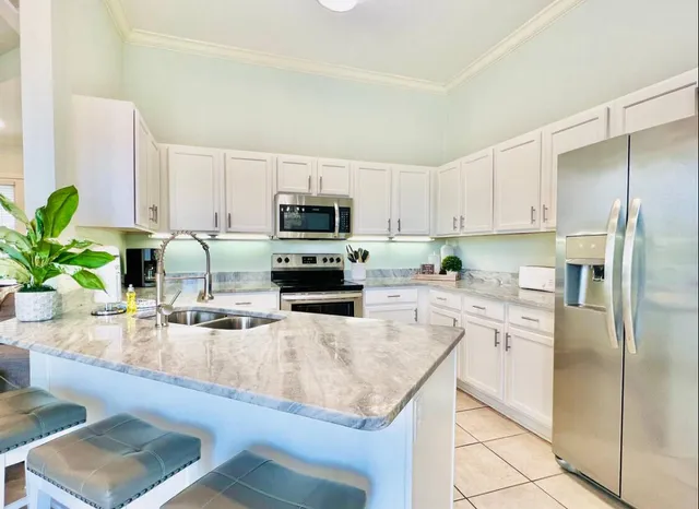 a kitchen with granite countertop a sink a counter top space appliances and cabinets
