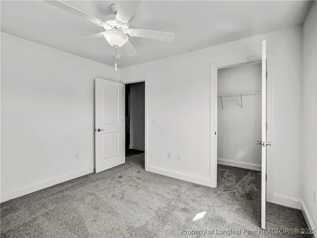 a view of an empty room with a ceiling fan