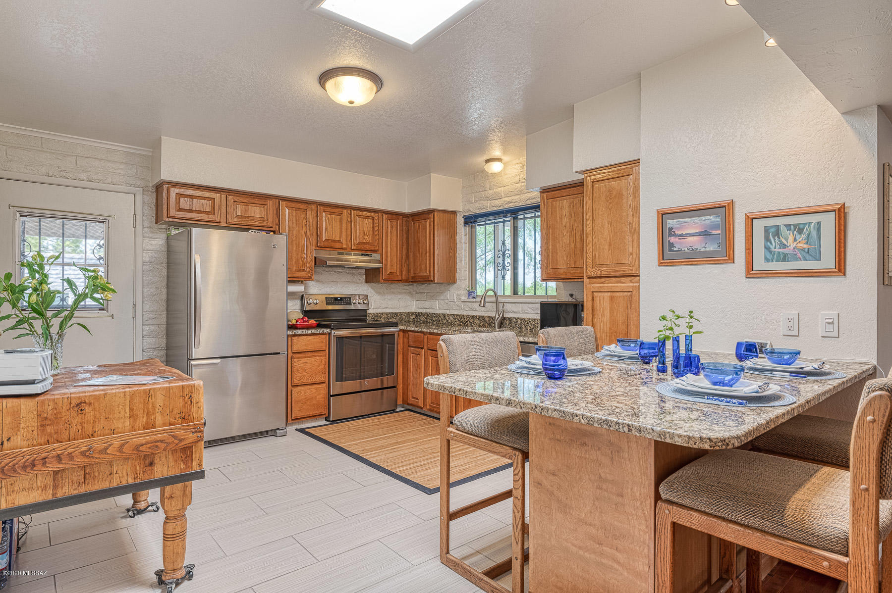 1825 North Old Ranch Road Tucson, AZ 85745 - Photo 8 of 35 a kitchen with stainless steel appliances granite countertop a refrigerator a sink a stove a dining table and chairs