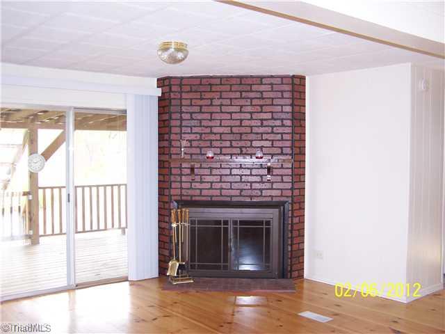 3802 Amostown Road Sandy Ridge, NC 27046 - Photo 8 of 16 Living Room. Brick Fireplace with tools.