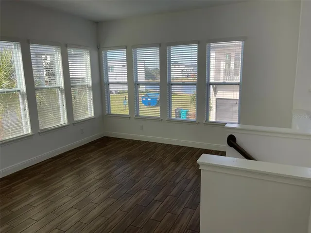 a view of a room with wooden floor and windows