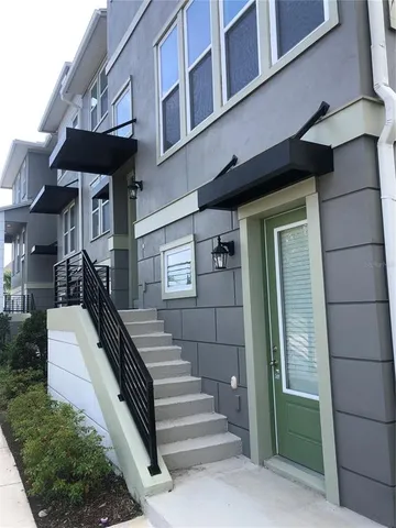 a view of a brick house with a small yard and plants
